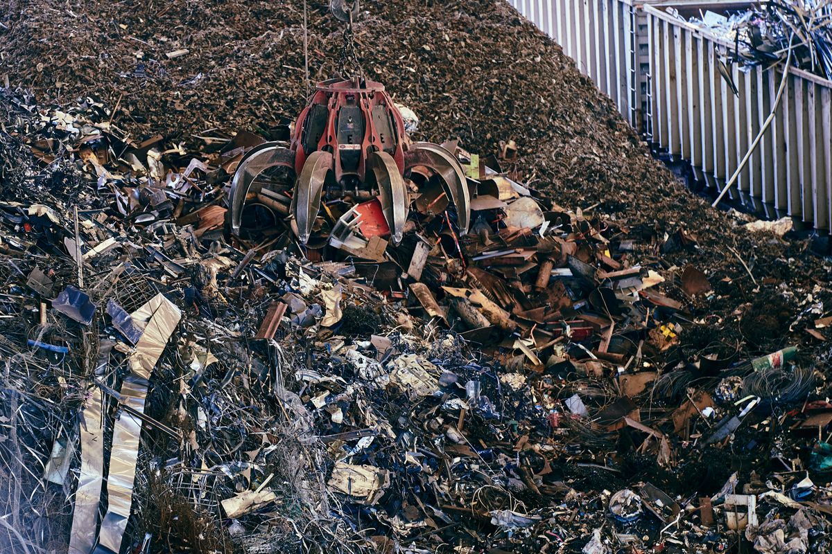 Excavator claw working in a scrap yard